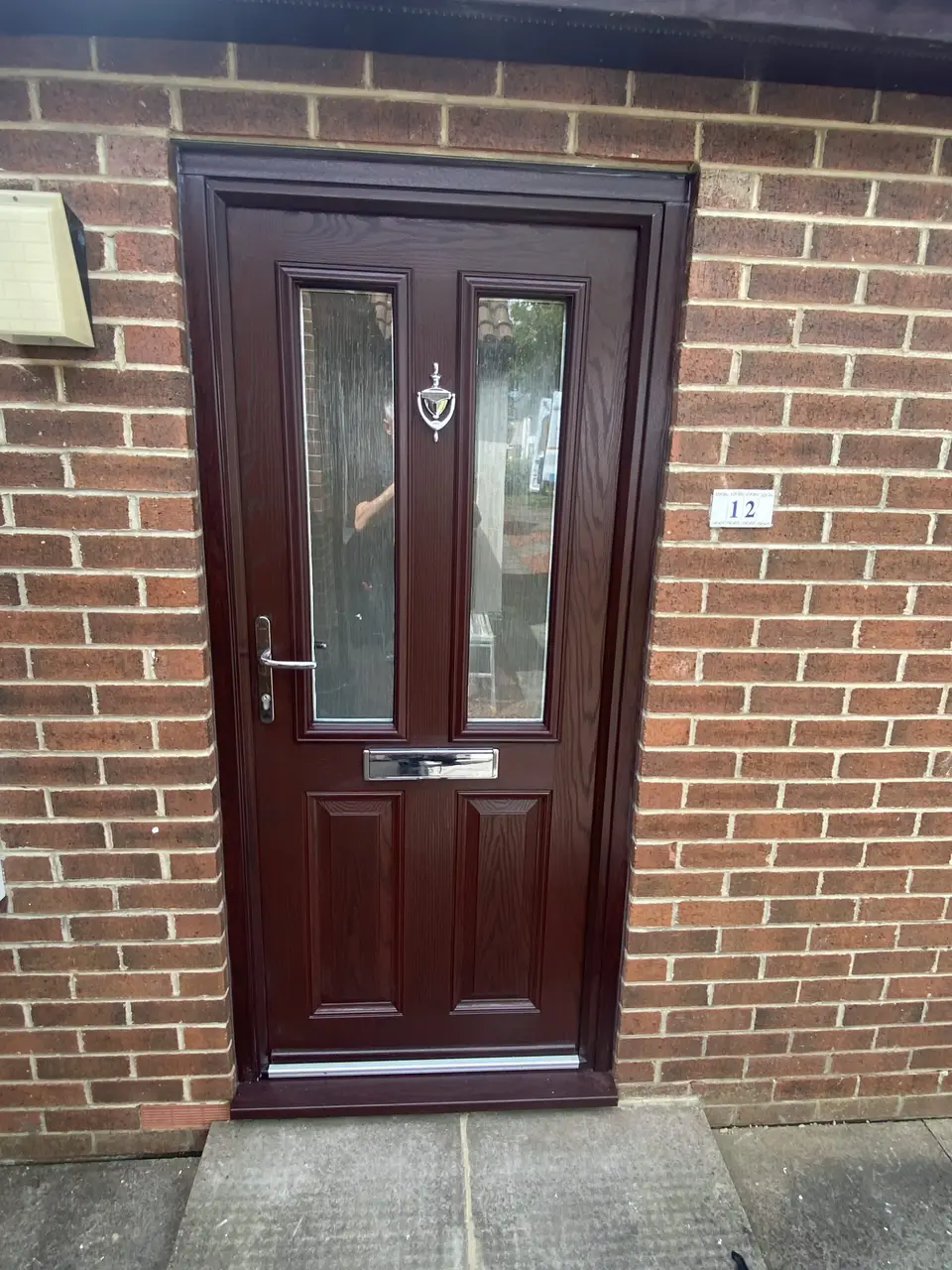 Rosewood composite front door in Newcastle Rosewood composite front door with twin glazed panels and chrome handle on a Newcastle home